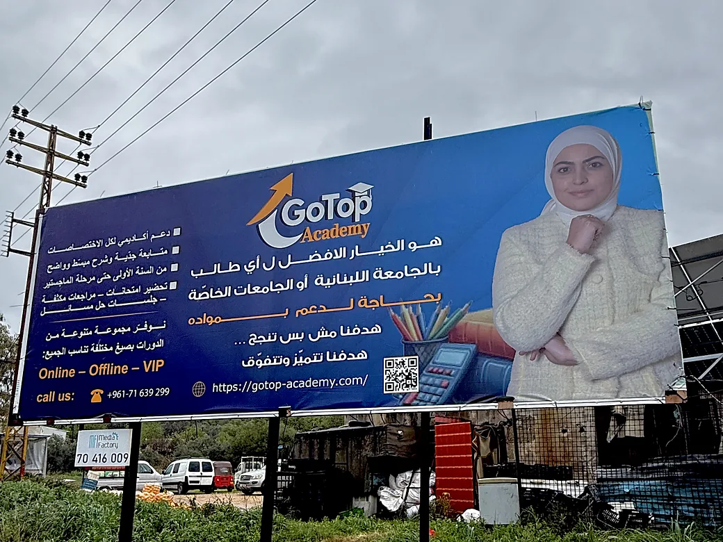 The GoTop Academy billboard from close up: Online, Offline and VIP courses and the phone number.